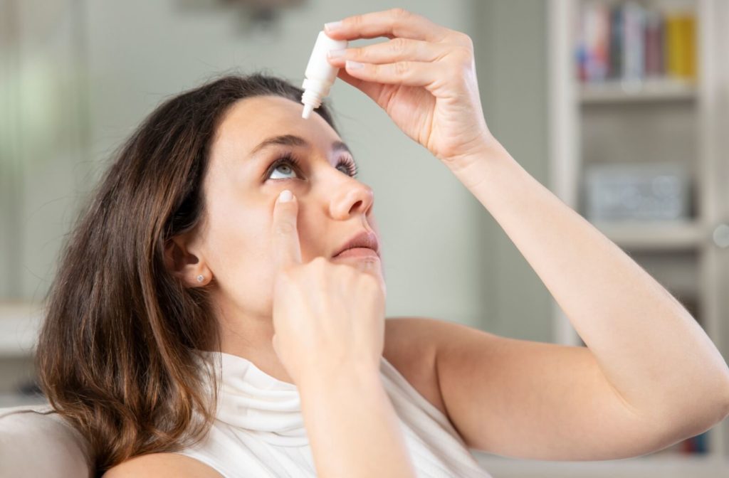 A woman applying artificial tears on her right eye.