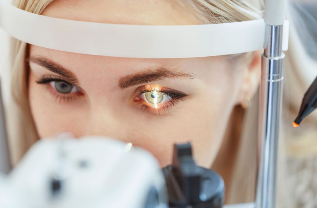 Alt text: A young patient undergoes a slit lamp examination to assess her eye health during her routine eye appointment.