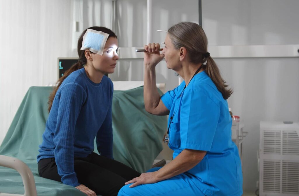 Woman receiving eye exam with light from healthcare professional.