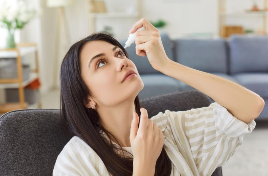 Person using lubricating eye drops at home to relieve dry eye discomfort and improve eye moisture.